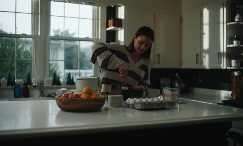 A clip of a lady cooking in the kitchen