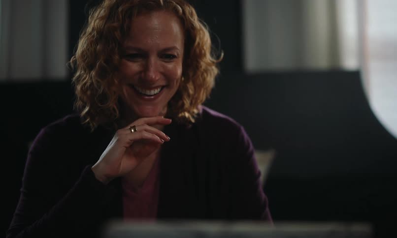 Woman in front of a laptop smiling