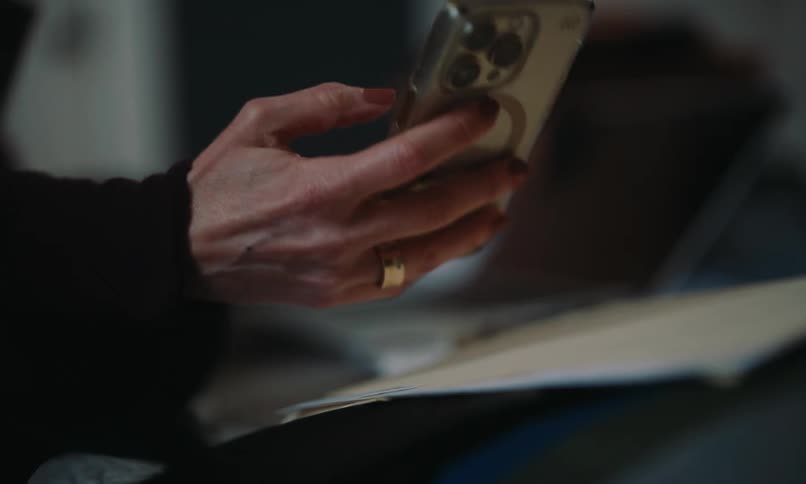 A woman is typing on her cell phone