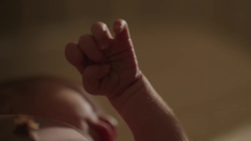 Close up on a newborn baby with hiccups