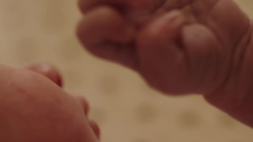 A baby moves his tiny hand around