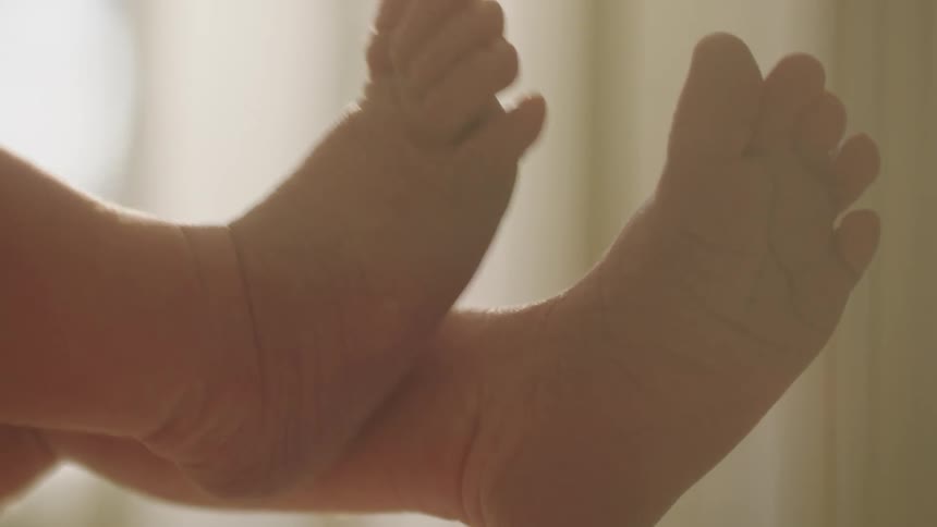 A baby is lifting his feet up