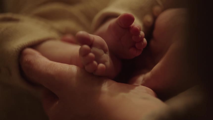 Pair of hands holding a babys feet