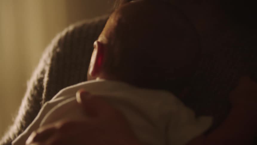 Mother sways with her baby resting on her chest