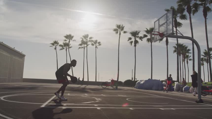 Man dribbling a basketball on an outdoor court