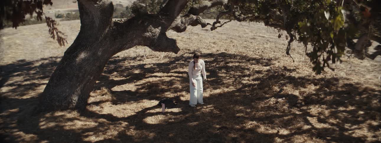 Woman in white clothes sitting under a tree