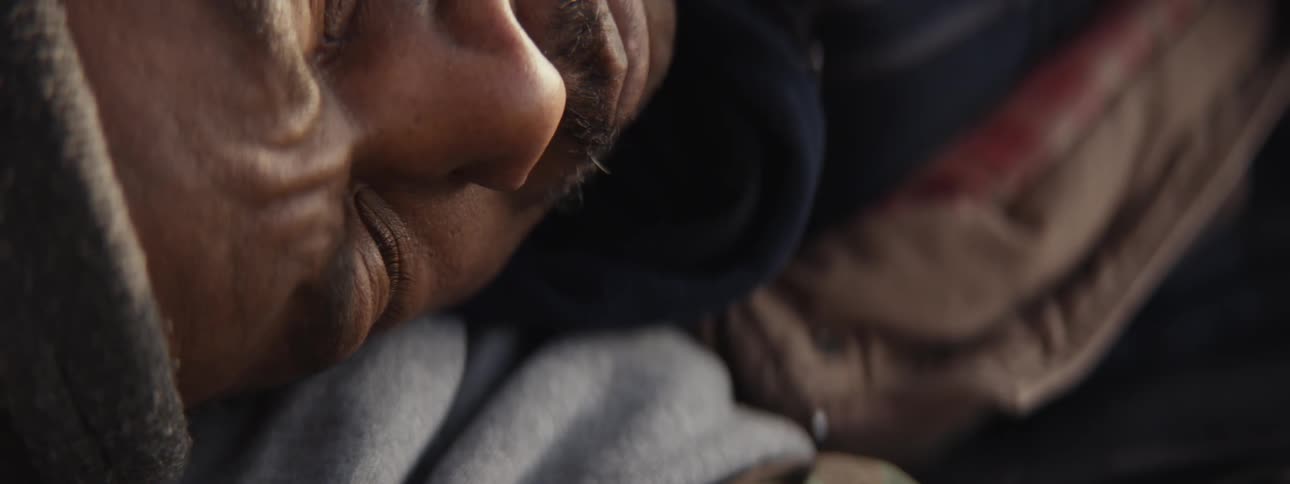 Close up of a man waking up and standing outdoors at a campsite