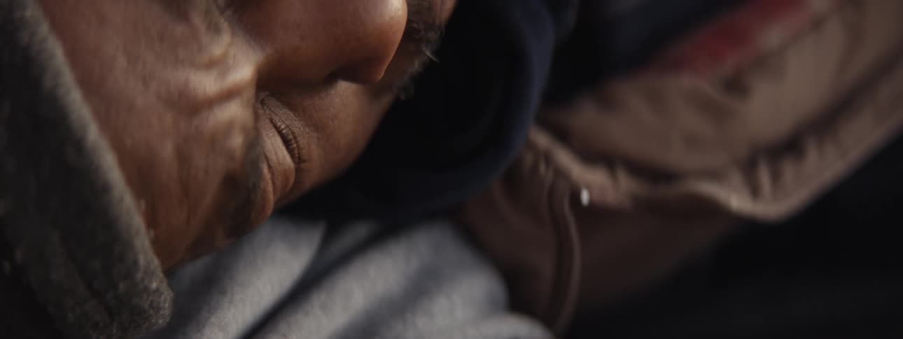 A man previously sleeping in a makeshift camp wakes up in the morning
