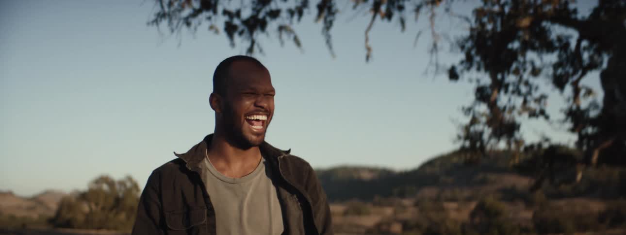 A clip of a man laughing and holding a drink