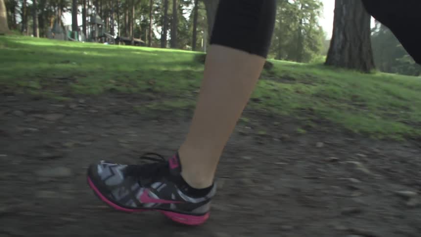 Woman running a trail in the woods