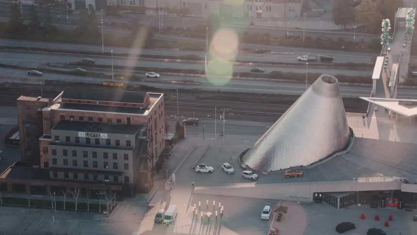 A highangle shot of a cityscape featuring the coneshaped structure of the museum of glass a contemporary art museum in tacoma washington