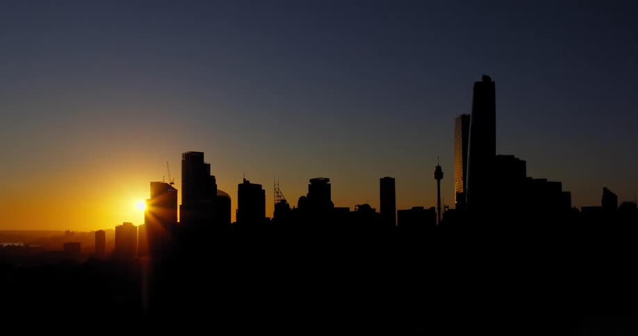 Aerial panorama of a metropolis skyline and the golden sunrise on the horizon