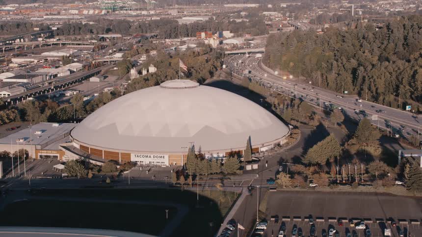 Aerial view of the tacoma dome surrounded by busy roads and wooded areas