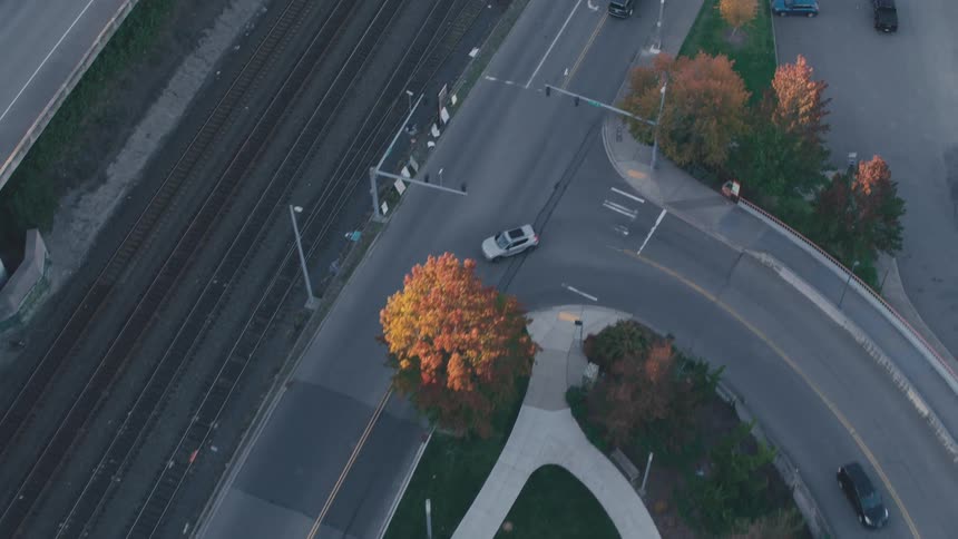 Vehicles drive along streets crossing and paralleling the railroad tracks