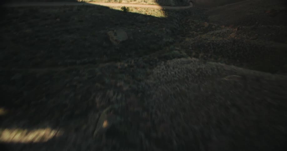 Aerial panorama of eroded mountains and canyons with access to a dirt road