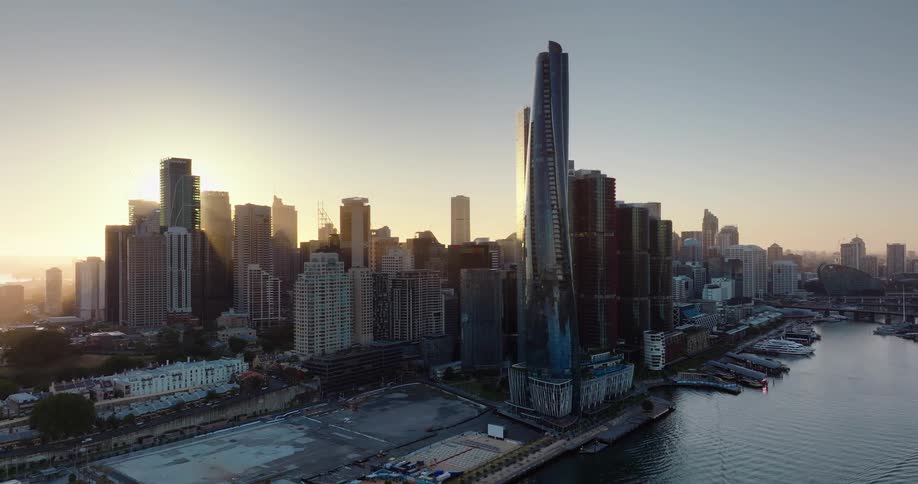 A metropolitan city with several highrise buildings next to a body of water and a clear sky day