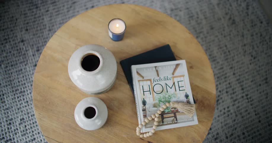 Interior architecture of a small wooden table with a magazine vases and lit candle