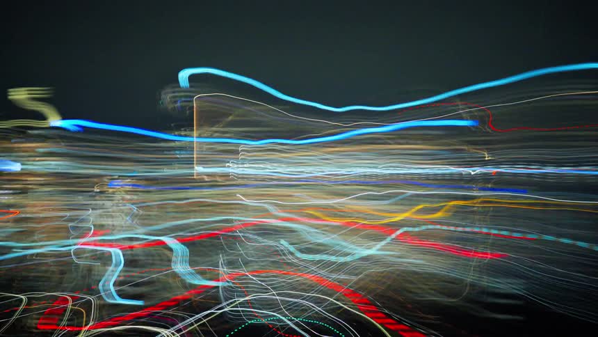 The movement of several lights of a city with huge buildings at night