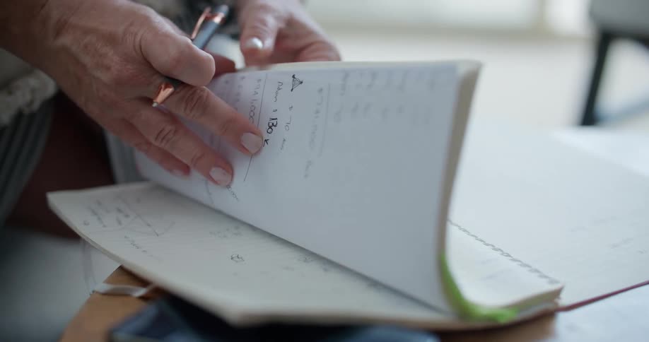 Person leafing through the pages of a notebook