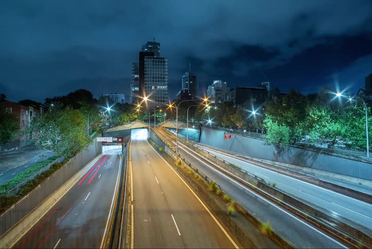 Highway with vehicle traffic in timelapse through a metropolis at night