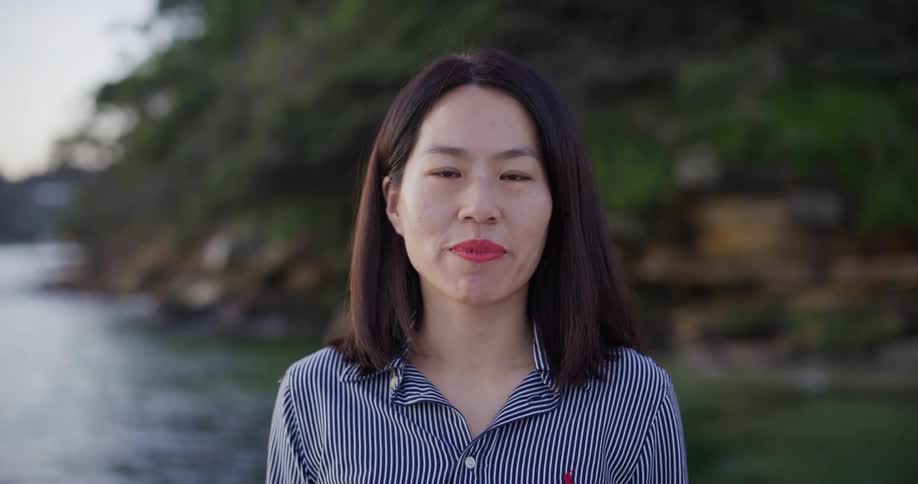 Portrait of a woman by the sea with the rocky coast in the background
