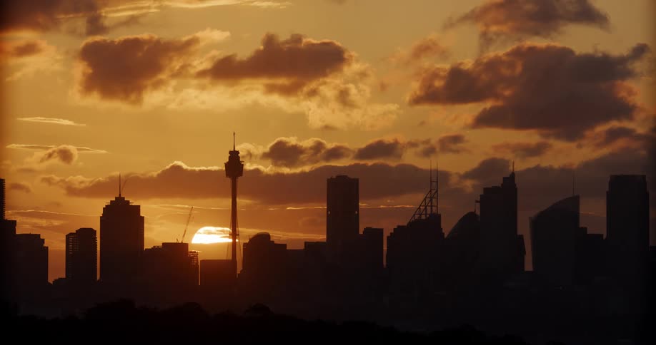 Panorama of the silhouette of a metropolis and the sun rising on the horizon