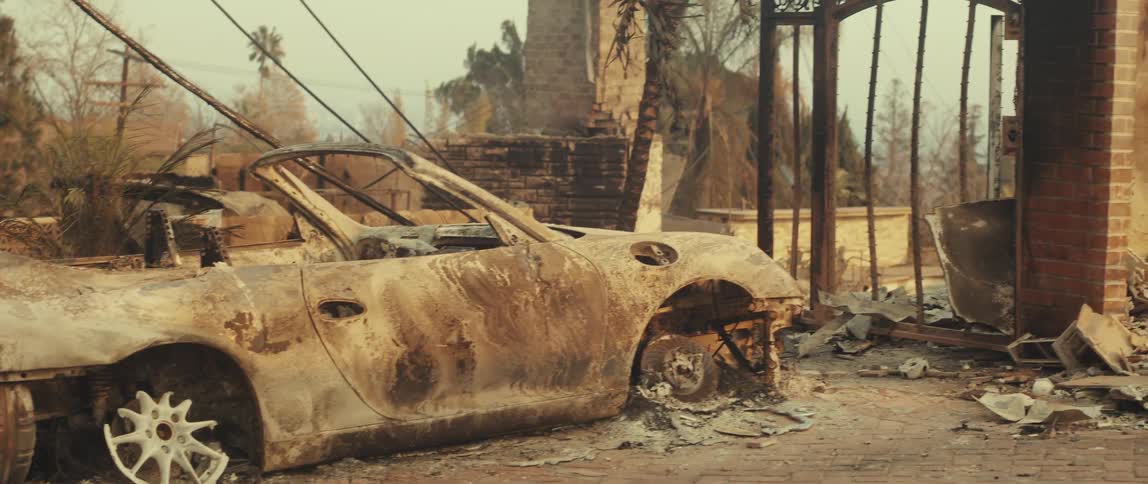 Burnt car and destroyed wall