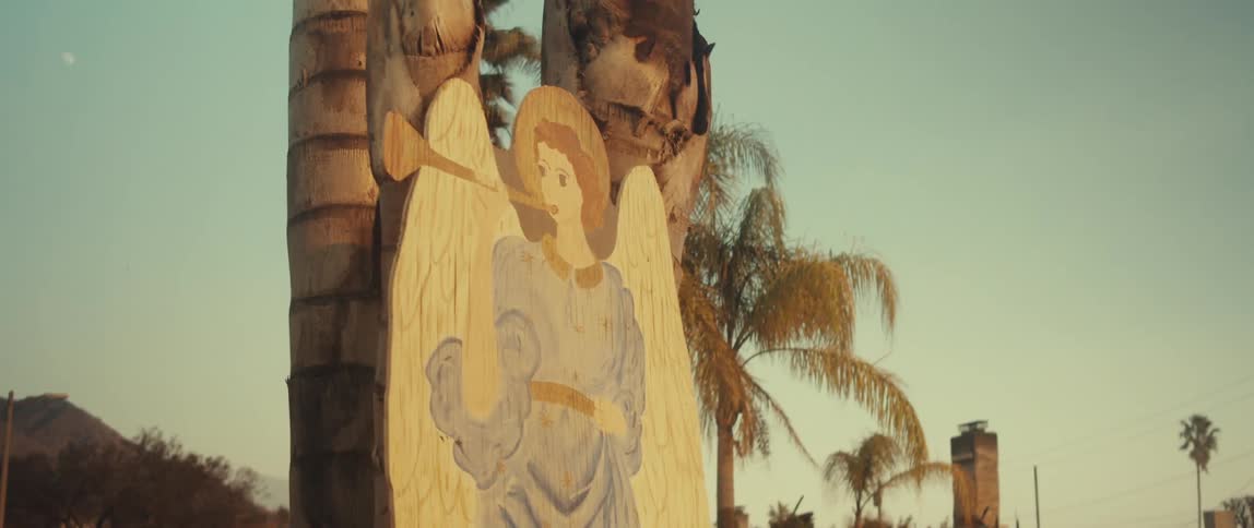Art of an angel next to tropical palm trees