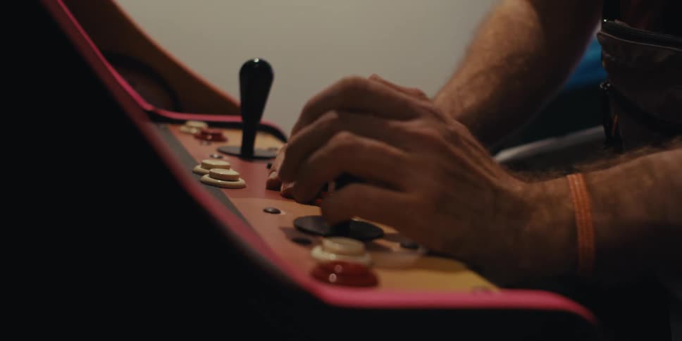 Pair of hands of a person playing pinball
