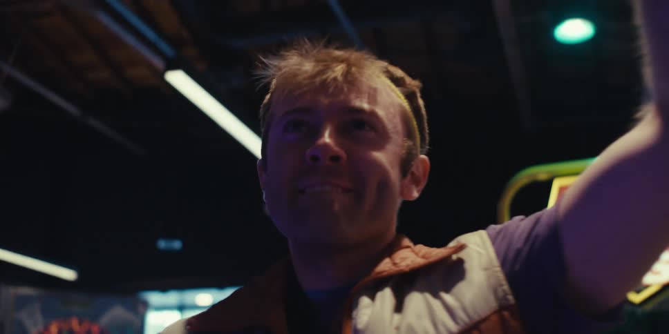 A man cheers as he plays an arcade game