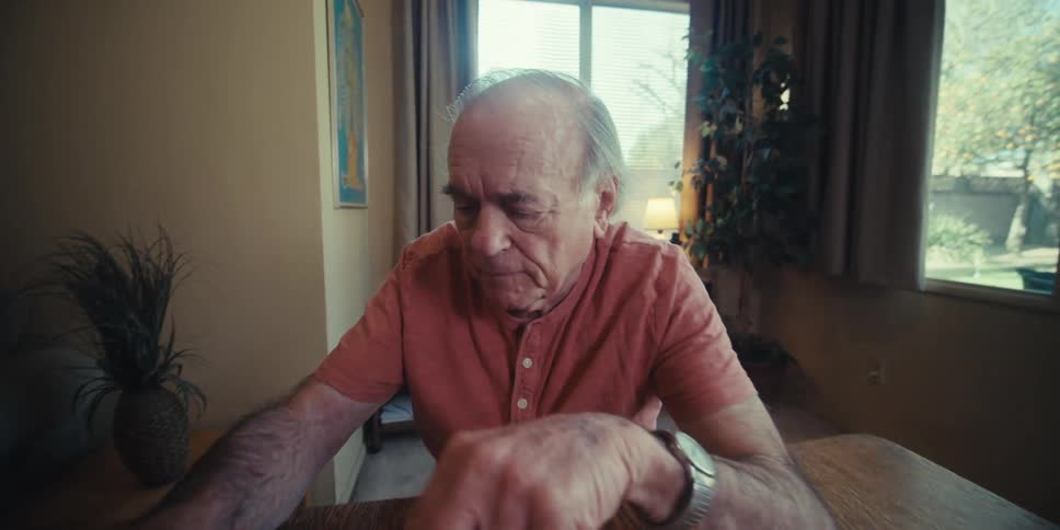 Elderly man playing chess with a young adult