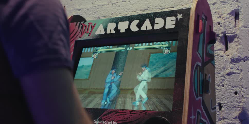 A person playing a fighting game in an old arcade machine