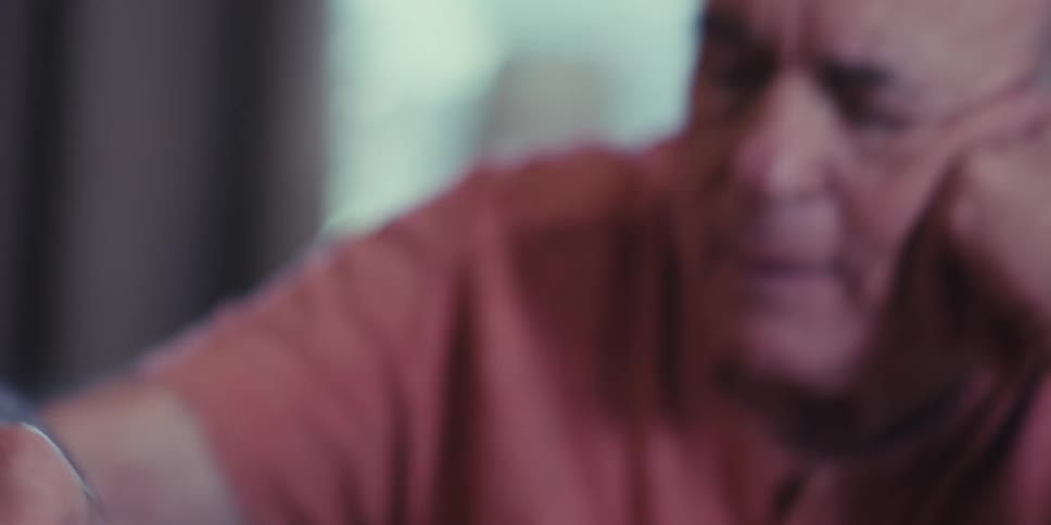 Elderly man sitting at table playing chess
