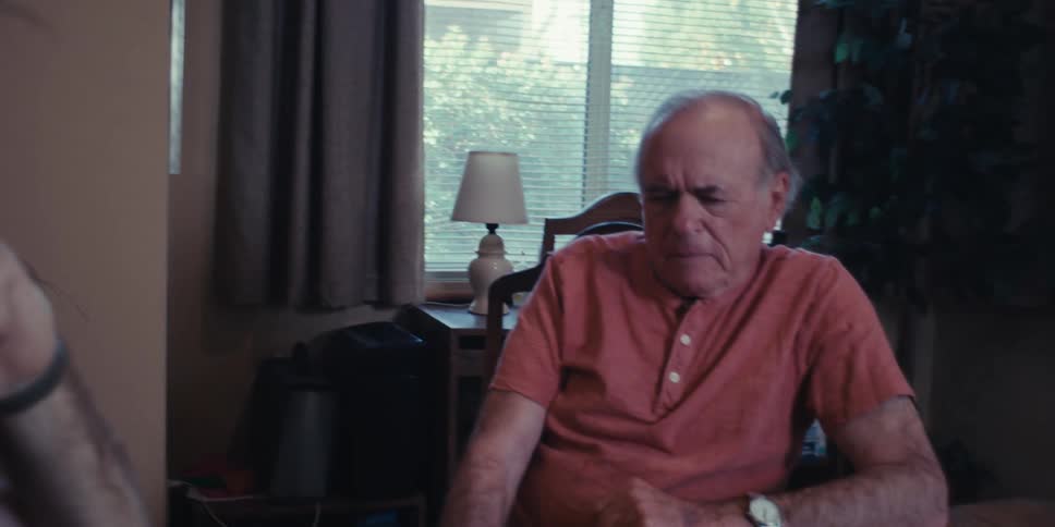 A father and son sit at the dining room table and play chess