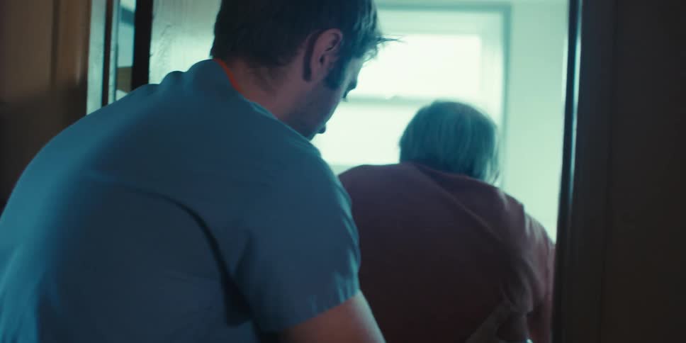 A man is assisted into the restroom