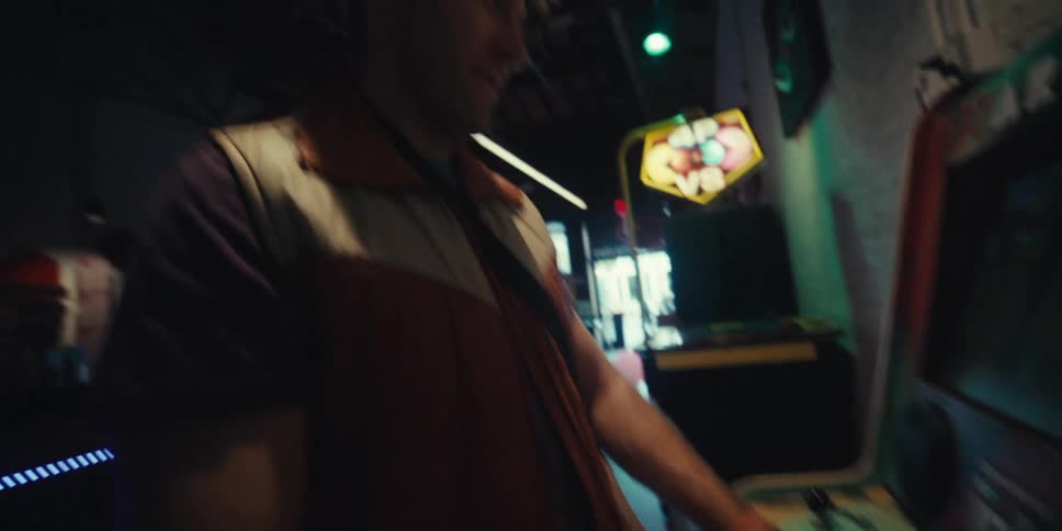 Man plays a fighting game at an arcade on a sunny day