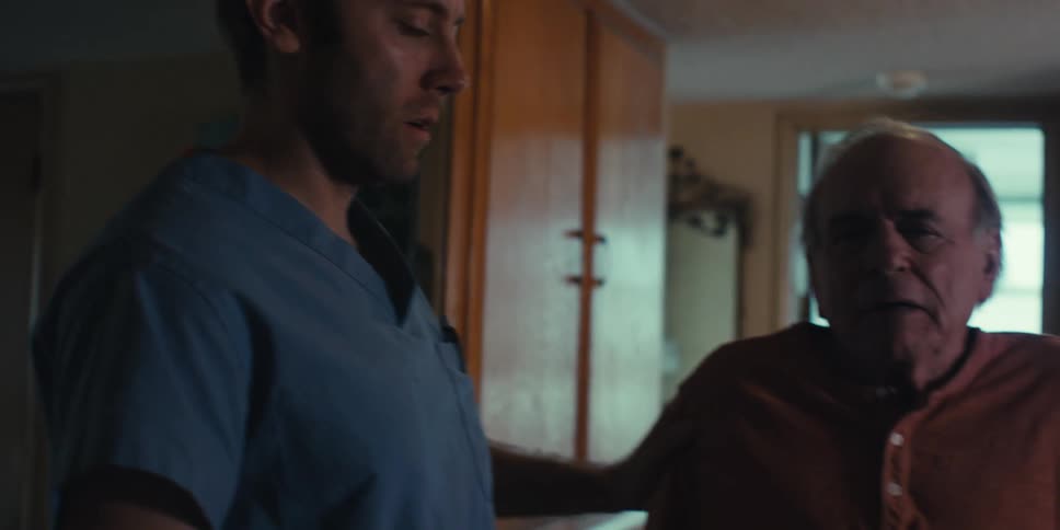 Elderly patient taking deep breaths next to a nurse