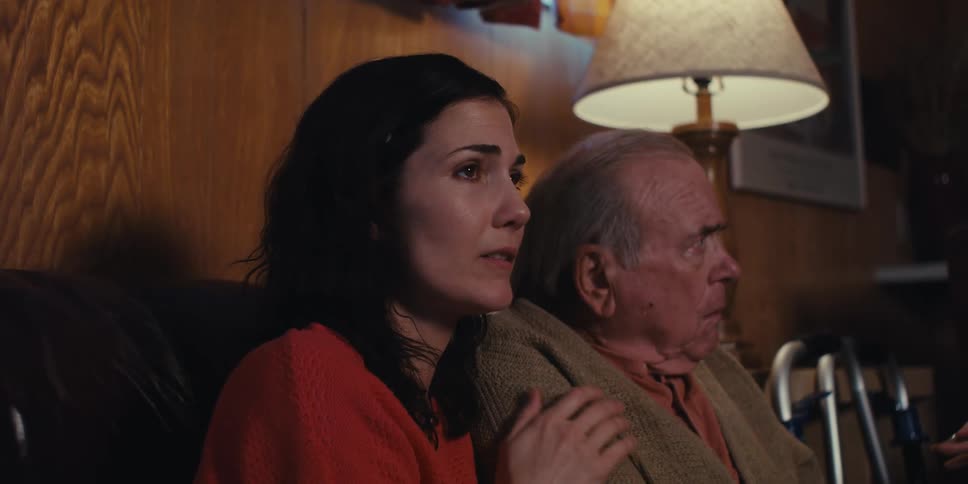 A woman shakes her head as she consoles her worried father