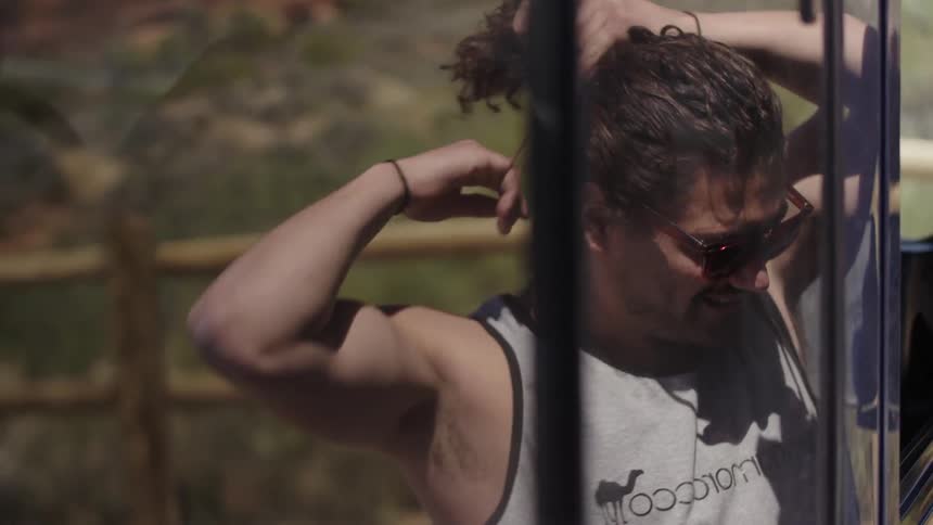 A man secures his hair with a hair elastic