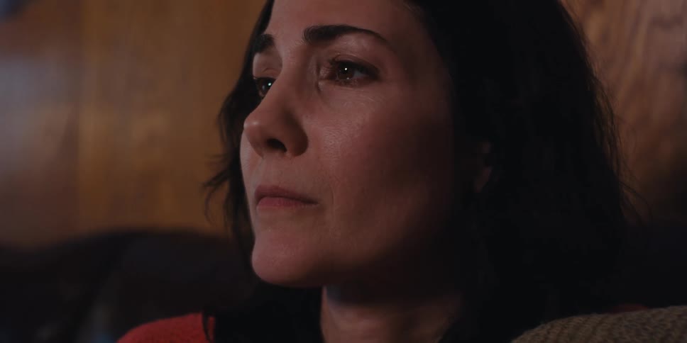 A young womans face with worried tones and there is an elderly man next to her crying
