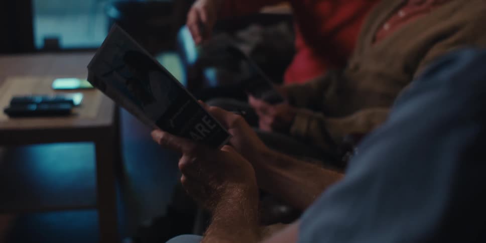 Elderly care specialist discusses a brochure with an elderly man and his daughter