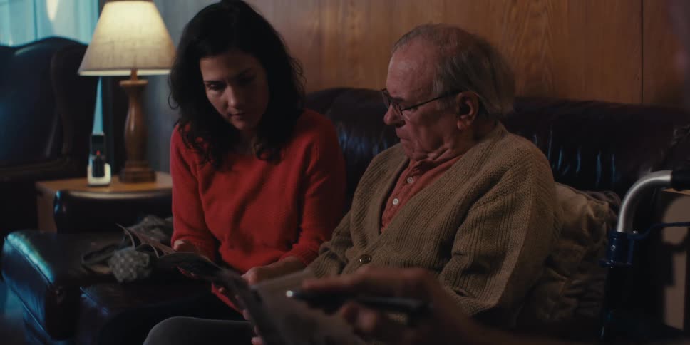 Nurse presenting a leaflet to an elderly man and his adult daughter