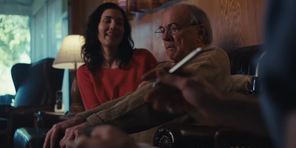 A nurse is taking notes and talking with a patient at home