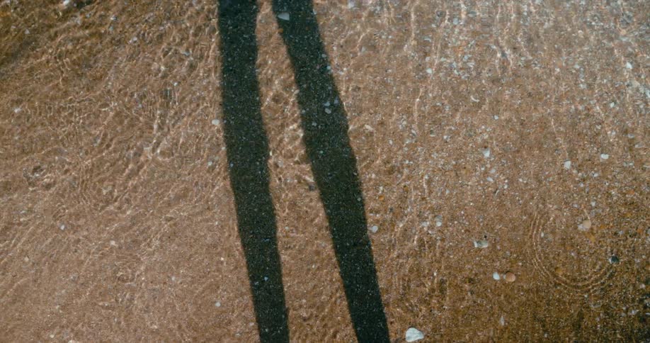 A persons shadow is on the sand