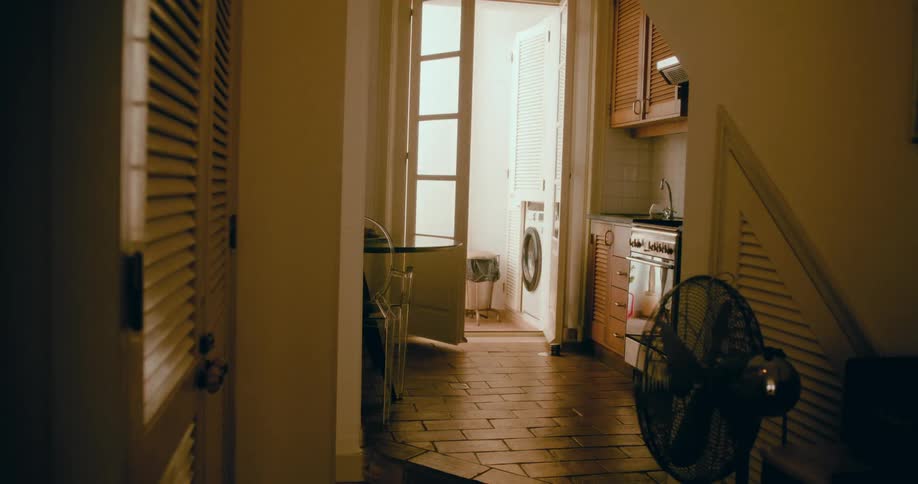 A back clip of a man walking past the corridor and towards the room