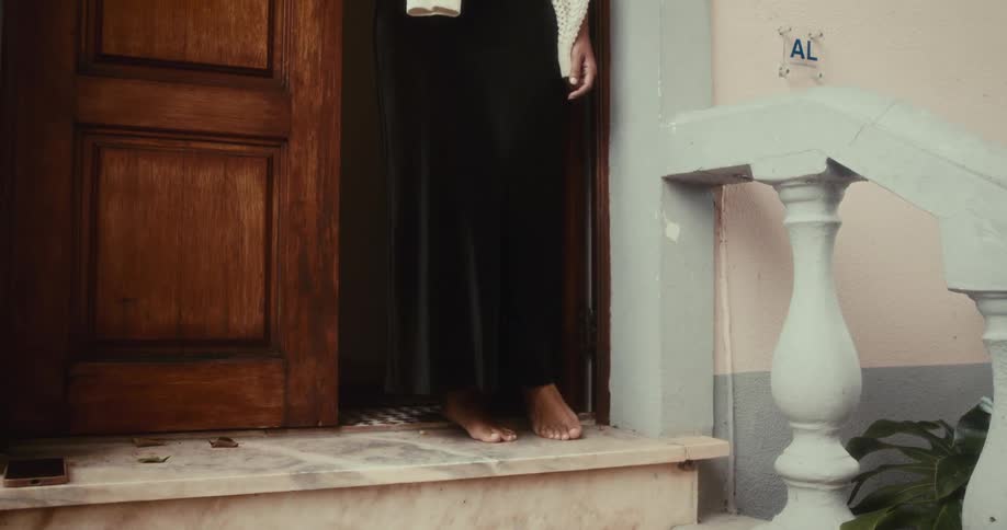 Legs of a person leaving the front door of a residence