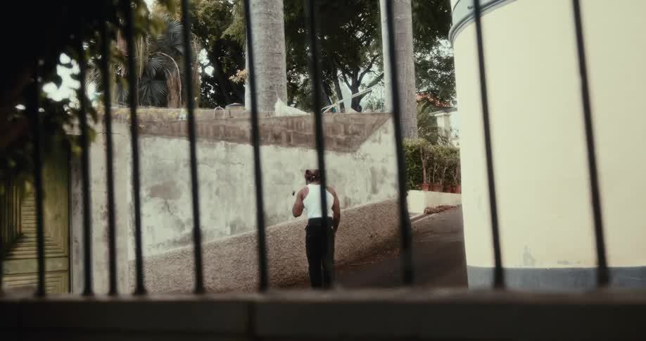 Man in regattas walking down a city street and lighting a pipe