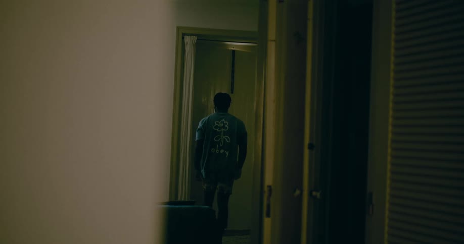 Man stretching his arms up and opening the curtain of a bedroom window
