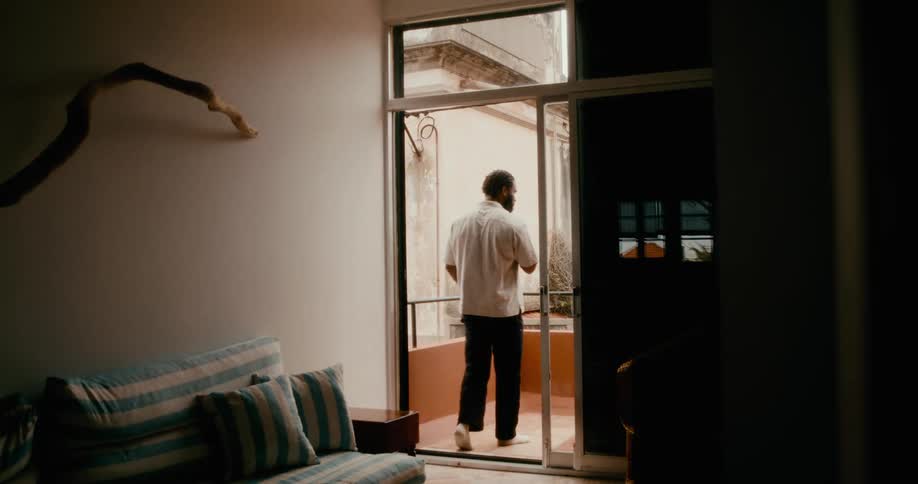 Man smoking a pipe on the balcony of the house