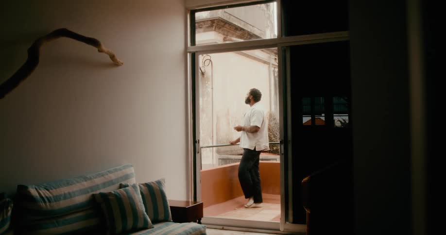 Man on the balcony of a house smoking a pipe